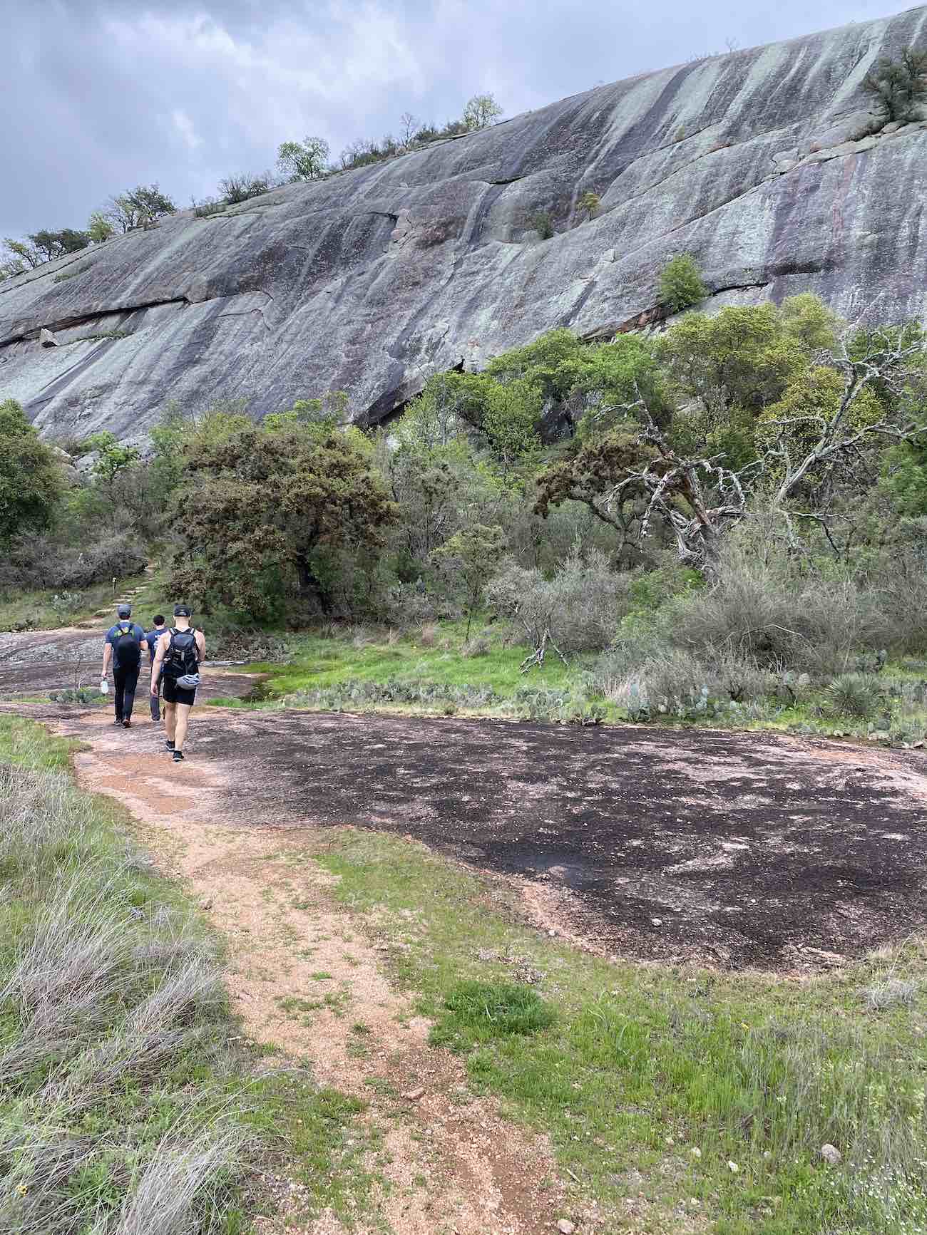 The group of climbers, hiking to the wall